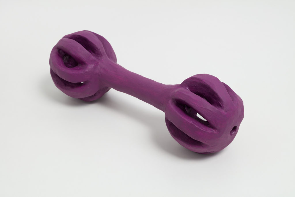 A ceramic sculpture of one of London’s dog toys that resembles a dumbbell. It is painted purple.