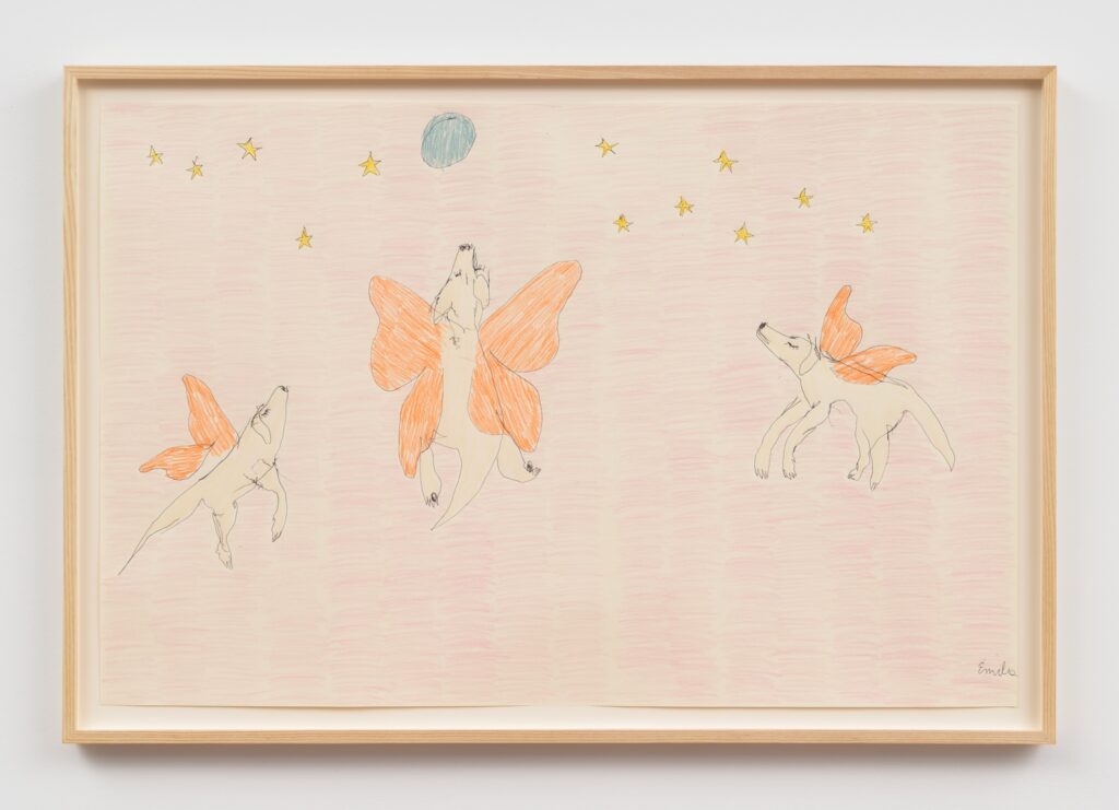 “Angel Dogs Flying to the Moon” is a colored crayon drawing on paper in a light wood frame. The drawing shows three blonde English Labrador Retrievers, each with large, orange butterfly wings. The Butterfly Dogs are positioned as if they are leaping or floating in the air. Above them, there are several yellow stars scattered across the top of the picture and a single blue circle, representing a moon. The background is filled with light pink shading. The drawing has a whimsical, childlike style.
