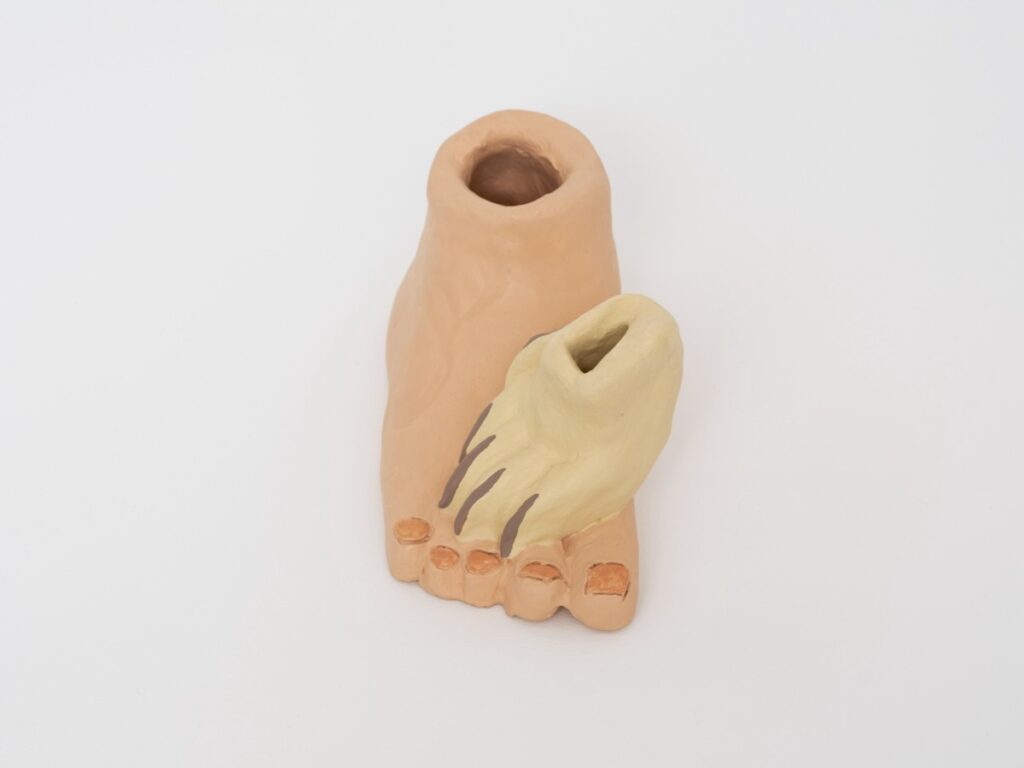 Detail view of "Paw on Foot", taken from above. The nails on the foot are painted a soft apricot color and the nails on the paw have been painted a grayish brown.